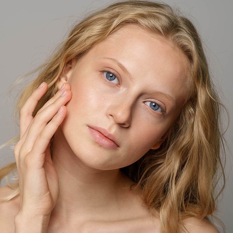 an image of a woman with blue eyes and blond hair, gray background